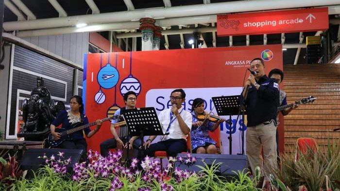 Kelompok band karyawan PT Angkasa Pura menghibur penumpang pesawat di bandara, Senin (1/1/2018).