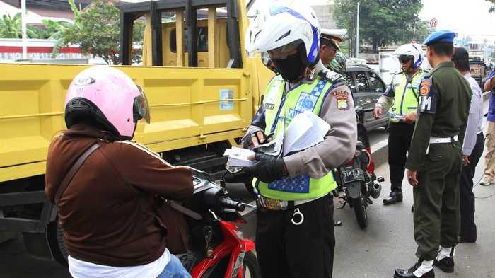 Petugas gabungan Kepolisian, Dishub dan TNI, melakukan penindakan terhadap para pengendara yang masuk ke jalur busway di Jalan Daan Mogot Km 13.5, Cengkareng, Jakarta Barat, Senin (13/6). (Foto: Warta Kota/Nur Ichsan)