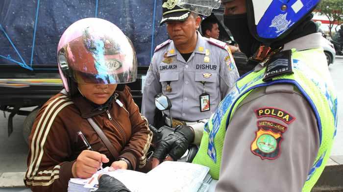 Petugas gabungan Kepolisian, Dishub dan TNI, melakukan penindakan terhadap para pengendara yang masuk ke jalur busway di Jalan Daan Mogot Km 13.5, Cengkareng, Jakarta Barat, Senin (13/6). (Foto: Warta Kota/Nur Ichsan)