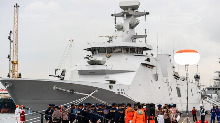 Anggota Polri dan Basarnas melihat proses identifikasi jenazah dan serpihan pesawat Sriwijaya Air SJ 182 rute Jakarta-Pontianak pada hari keenam Operasi SAR pesawat tersebut di Dermaga JICT 2, Tanjung Priok, Jakarta Utara, Kamis (14/1/2021).