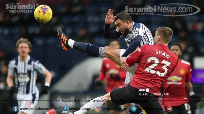 Gelandang West Bromwich, Albion Robert Snodgrass (kiri) memainkan bola di bawah tekanan dari bek Manchester United Luke Shaw (kanan) selama pertandingan sepak bola Liga Utama Inggris di stadion The Hawthorns di West Bromwich, Inggris tengah, Minggu (14/2/2021).