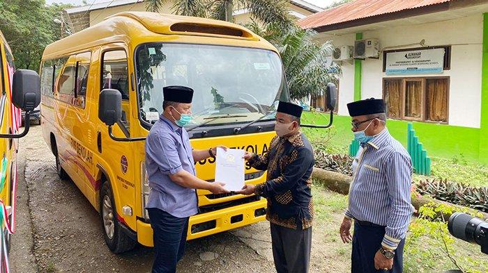 H Irmawan menyerahkan bus kepada Pemkab Aceh Besar yang diterima oleh Asistem II Muhammad Ali disaksikan Kadis Perhubungan Aceh Besar Azhari, Selasa, (22/12).