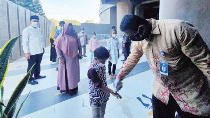 Kepala Dinas Kebudayaan dan Pariwisata Aceh, Jamaluddin (kiri) memantau penerapan protokol kesehatan (protkes) pengunjung Museum Tsunami Aceh, Jumat (19/2/2021).