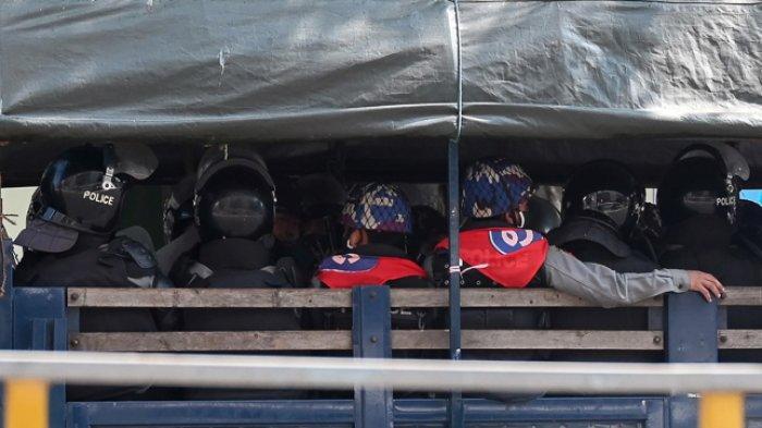 Pasukan polisi duduk di sebuah truk di pusat kota Yangon pada 1 Februari 2021, ketika militer Myanmar menahan pemimpin de facto negara itu Aung San Suu Kyi dan presiden negara itu dalam kudeta.