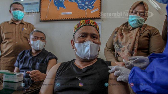 Petugas medis menyuntikan vaksin covid19 kepada Ketua DPRK Aceh Besar, Iskandar Ali yang di damping oleh Wakil Ketua DPRK, Bahtiar di Pukesmas Ingin Jaya, Aceh Besar, Senin (18/1/2021). SERAMBI/HENDRI
