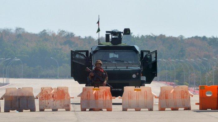 Seorang tentara berjaga di jalan yang diblokade menuju parlemen Myanmar di Naypyidaw pada 1 Februari 2021, setelah militer menahan pemimpin de facto Aung San Suu Kyi dan presiden negara itu dalam kudeta.
