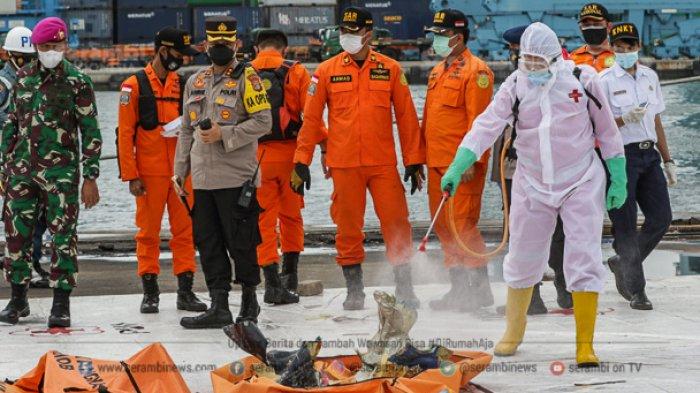 Petugas sterilisasi serpihan pesawat Sriwijaya Air SJ 182 rute Jakarta - Pontianak yang jatuh di perairan Kepulauan Seribu di Posko SAR Sriwijaya Air, Dermaga JICT II, Tanjung Priok, Jakarta, Rabu (13/1/2021).