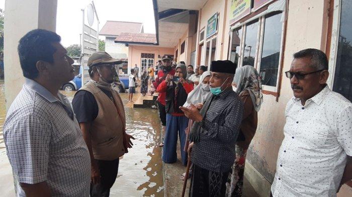 Wakil Bupati Aceh Besar, Tgk Husaini A Wahab (dua dari kanan) didampingi Kadis Sosial, Bahrul Jamil SSos MSi (kiri) meninjau banjir sekaligus menyerahkan bantuan masa panik bagi korban banjir yang mengungsi di SD Gampong Garot, Kecamatan Darul Imarah, Minggu (11/7/2021)