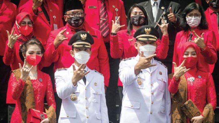 Wali Kota Solo Gibran Rakabuming Raka beserta istri Selvi Ananda dan Wakil Wali Kota Teguh Prakosa beserta istri Sherly Yusnita berfoto bersama usai upacara pengambilan sumpah jabatan dan pelantikan Wali Kota dan Wakil Wali Kota Solo di kantor DPRD Kota Solo, Jawa Tengah, Jumat (26/2/2021).