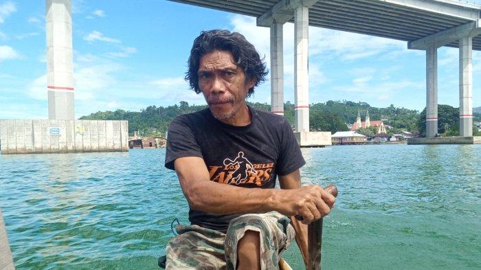 AMBON: Eric Lesnussa, saat mendayung mengantarkan penumpang menyusuri Teluk Ambon, Kota Ambon, Selasa (23/2/2021).