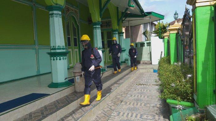 AMBON - Menggunakan APD lenngkap KBR Brimob Polda Maluku lakukan penyemprotan cairan disenfektan pada Masjid Kota Ambon Jumat, (5/2/2021).