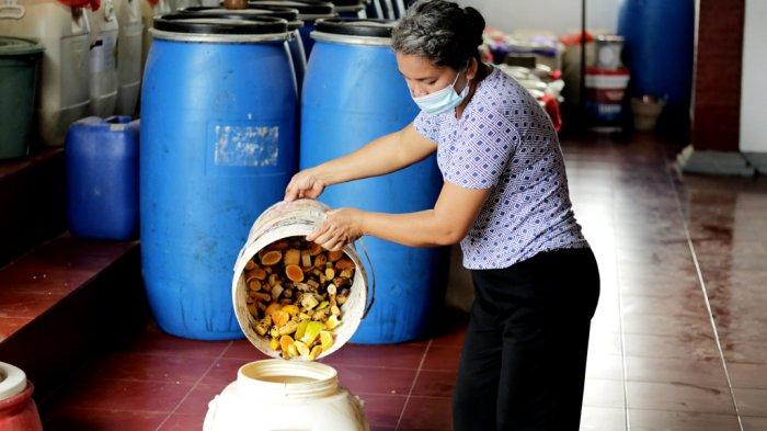 Janarti saat membuat pupuk eco enzyme dari sampah buah sisa upakara