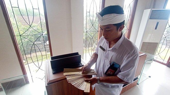 Koordinator Penyuluh Bahasa Bali Kabupaten Jembrana, I Nengah Yoga Darma Adiputra saat menunjukkan salah satu cakep lontar yang jadi koleksi Museum Banten dan Lontar Jembrana, Rabu 14 Desember 2022.