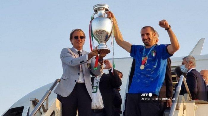 Gambar selebaran ini diambil dan dirilis oleh Aereoporti Di Roma (ADR) pada 12 Juli 2021 menunjukkan pelatih Italia Roberto Mancini (kiri) dan Giorgio Chiellini memegang trofi Kejuaraan Eropa setelah Italia memenangkan pertandingan sepak bola final UEFA EURO 2020 antara Italia dan Inggris, saat mereka tiba di bandara Fiumicino Roma di Roma.