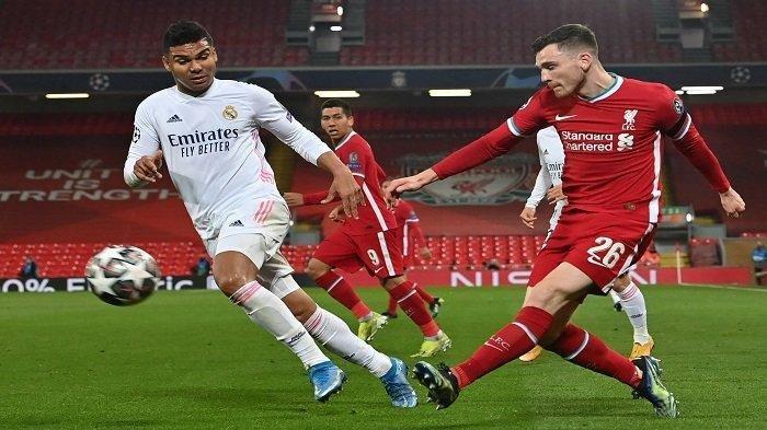 Gelandang Real Madrid Brasil Casemiro (kiri) bersaing dengan bek Liverpool asal Skotlandia Andrew Robertson dalam pertandingan leg kedua perempat final Liga Champions UEFA antara Liverpool dan Real Madrid di Anfield di Liverpool, barat laut Inggris pada 14 April 2021.