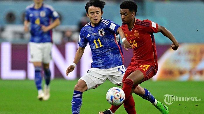 Gelandang Jepang Takefusa Kubo (kiri) berebut bola dengan bek Spanyol Alejandro Balde selama pertandingan sepak bola Grup E Piala Dunia Qatar 2022 antara Jepang dan Spanyol di Stadion Internasional Khalifa di Doha pada 1 Desember 2022. Klasemen akhir Grup E Piala Dunia 2022, Jepang dan Spanyol berhasil ke 16 besar. AFP/JAVIER