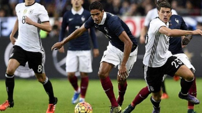 Bek Prancis Raphael Varane (tengah) bersaing merebut bola dengan pemain Jerman Mario Gomez (kanan) pada laga persahabatan di Stadion Stade de France, Jumat (13/11/2015) waktu setempat.