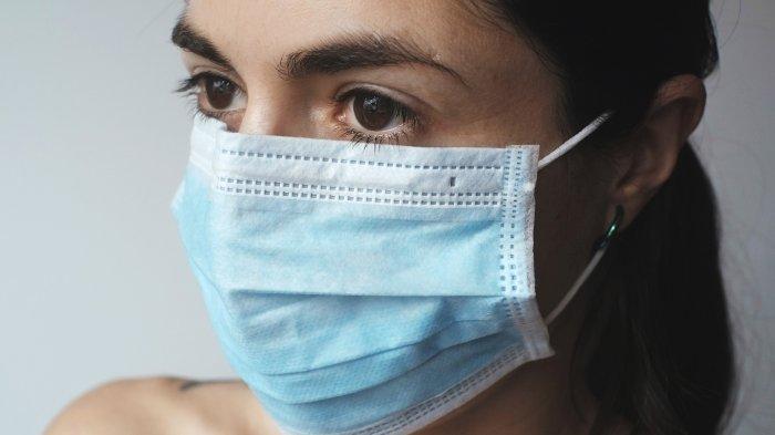 Perempuan menggunakan masker