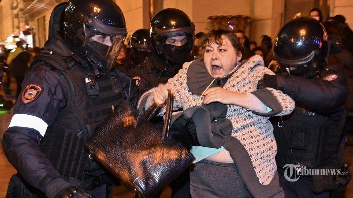 Petugas polisi menahan seorang wanita di Moskow pada 21 September 2022, menyusul seruan untuk memprotes mobilisasi parsial yang diumumkan oleh Presiden Vladimir Putin. - Presiden Vladimir Putin memanggil pasukan cadangan militer Rusia pada 21 September, mengatakan janjinya untuk menggunakan semua sarana militer di Ukraina