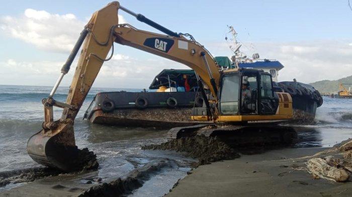 Petugas sedang mengevakuasi tagboat menggunakan alat berat, Kamis (14/7/2022). Tagboat tenggelam setelah ditarik ke tengah laut.
