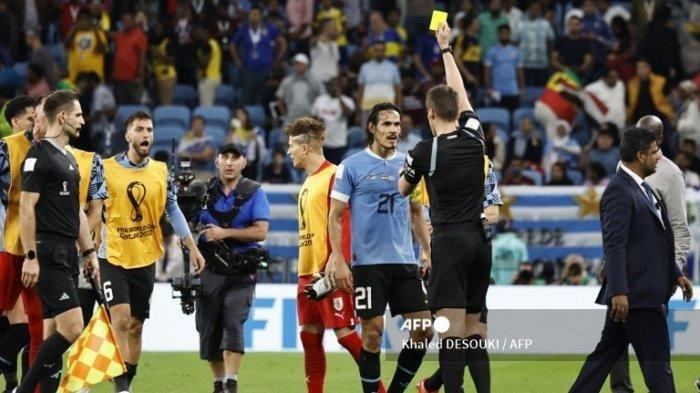 Wasit Jerman Daniel Siebert memberikan kartu kuning kepada penyerang Uruguay #21 Edinson Cavani setelah berakhirnya pertandingan sepak bola Grup H Piala Dunia 2022 Qatar antara Ghana dan Uruguay di Stadion Al-Janoub di Al-Wakrah, selatan Doha pada 2 Desember, 2022.Khaled DESOUKI / AFP
