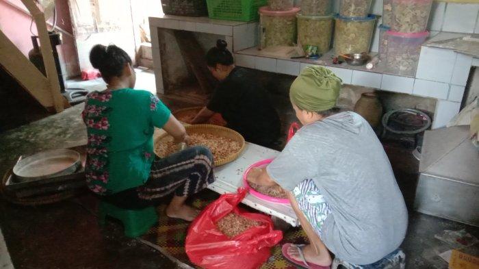 Beberapa karyawan di rumah Ellia tampak sibuk memisahkan kulit kacang untuk pembuatan kue lebaran, Kamis (22/4/2021)