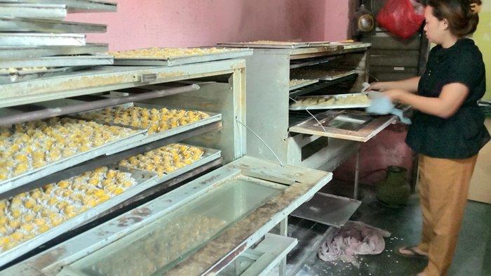 Septi tampak sedang memasukan kue ke dalam oven dan mengangkat yang sudah matang untuk diangkat.