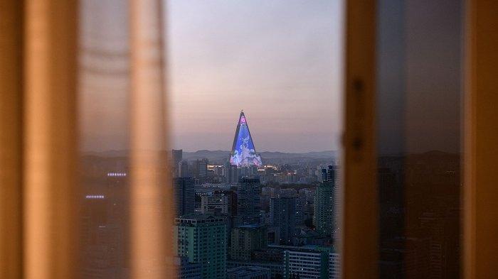 Pertunjukan cahaya ditampilkan di hotel Ryugyong terlihat dari hotel Yanggakdo di Pyongyang