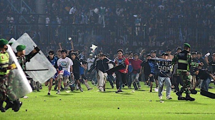 Suporter Arema FC, Aremania menerobos ke dalam lapangan usai Arema FC dikalahkan Persebaya Surabaya dengan skor 2-3 dalam laga lanjutan Liga 1 2022 di Stadion Kanjuruhan, Malang, Sabtu (1/10/2022).