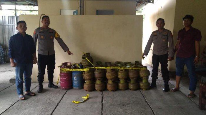 Personel Polsek Pangkalan Baru menunjukkan barang bukti elpiji yang dioplos oleh pelaku bernama Riko.