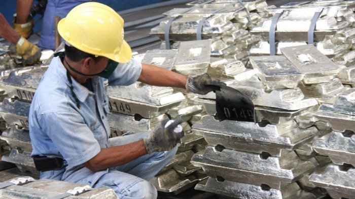 Karyawan PT Timah Tbk memeriksa timah batangan hasil produksi perusahaan.