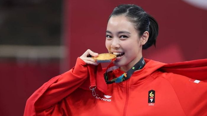 Lidswell Kwok menggigiti medali emasnya
