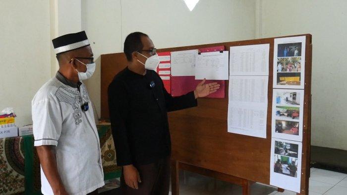 Jubir Covid-19 yang sekaligus Sekretaris desa Mislak, Hajarul Aswad di dampingi kepala desa Mislak, Yuzir AU saat menunjukkan papan informasi dan data grafis Covid-19 di desanya.