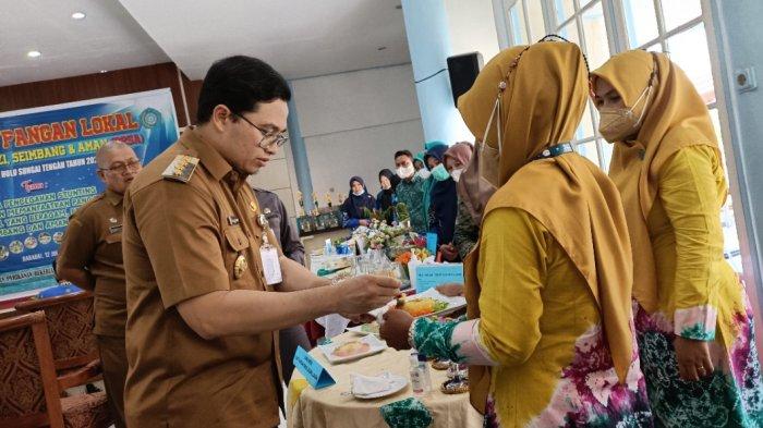 Bupati HST mencicipi menu pangan lokal berbahan jagung salah satu peserta.