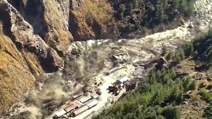 Banjir besar berisi air, lumpur dan puing-puing yang mengalir di Distrik Chamoli setelah sebagian gletser longsong di Himalaya memutus daerah Tapovan di negara bagian utara Uttarakhand, India, pada Minggu (7/2/2021).