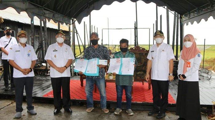 Korban kebakaran mendapat dokumen kependudukan yang baru dan juga bantuan lainnya, setelah diserahkan Bupati H Achmad Fikry, di bekas lokasi musibah, di Desa Bajayau Tengah RT 02 RW 02, Kecamatan Daha Barat, Kabupaten Hulu Sungai Selatan (HSS), Provinsi Kalimantan Selatan, Rabu (19/5/2021).
