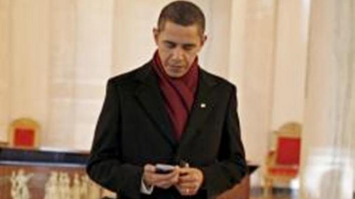 Presiden Amerika Serikat (AS), Barrack Obama menggunakan telepon selulernya.