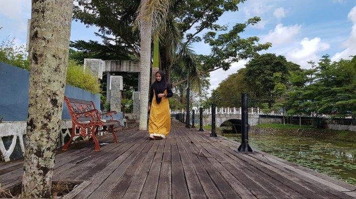 Pengunjung berjalan santai di selasar Orchid Park di dekat tepian sungai buatan setempat