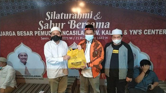 Penyerahan bingkisan oleh YNS Cemter dan MPW Pemuda Pancasila Kalsel kepada warga.
