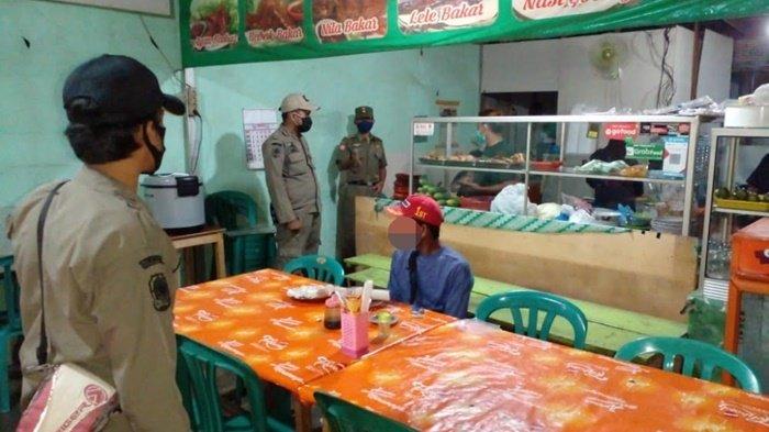 Petugas saat menyampaikan aturan terkait penerapan PPKM Level 4 di salah satu tempat makan di Kota Banjarbaru, Provinsi Kalimantan Selatan