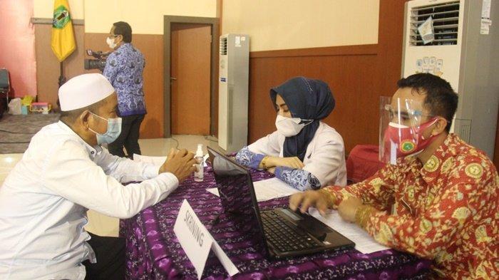Proses skrining dalam kegiatan vaksinasi Covid-19 berlangsung di Aula Ideham Khalid, Kota Amuntai, Kabupaten Hulu Sungai Utara (HSU), Provinsi Kalimantan Selatan, Rabu (17/3/2021).