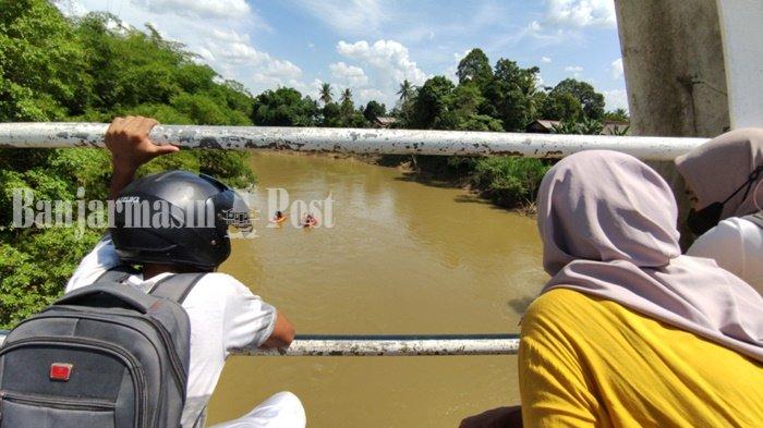 Warga dari Jembatan 1 Juli Hikun menyaksikan petugas melakukan pencarian seorang perempuan diduga tenggelam di Sungai Tabalong, kawasan perbatasan Kelurahan Hikun, Kecamatan Tanjung dan Desa Kapar Kecamatan Murung Pudak, Kabupaten Tabalong, Provinsi Kalimantan Selatan, Senin (19/7/2021)