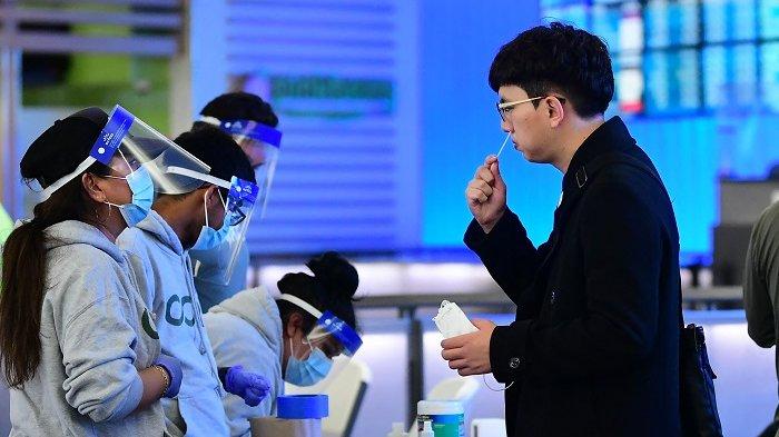 Seorang pria menyeka hidungnya di tempat pengujian cepat Covid-19 di terminal internasional di Bandara Internasional Los Angeles pada 3 Desember 2021, saat Los Angeles County melaporkan kasus pertama varian omicron. Tes gratis ditawarkan kepada siapa saja yang tiba di Los Angeles yang mungkin merasa sakit dari negara mana pun yang melaporkan kasus varian omicron baru.