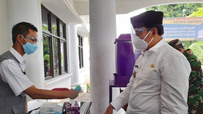 Gubernur Banten Wahidin Halim mengecek suhu tubuhnya sebelum membuka resmi vaksinasi perdana di Pendopo Bupati Tangerang, Kamis (14/1/2021).