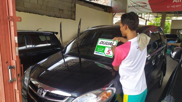 Seorang penjual mengelap mobil bekas yang dijual di sebuah showroom di Letnan Jidun, No 9 Kepandean, Kota Serang, Senin (14/12/2020).