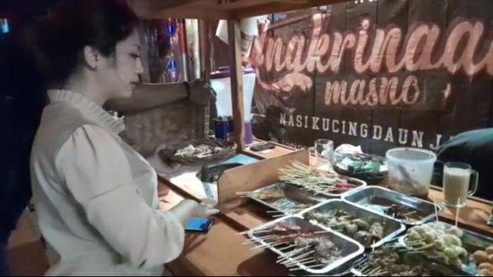 Shilvi Elviana melayani pembeli dari balik gerobak Angkringan Mas No.