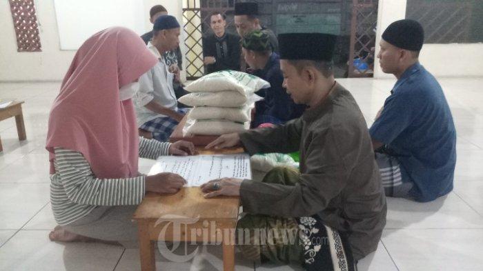 ZAKAT FITRAH - Amil zakat Musola Miftahul Jannah, Kp Pondok Cikurus Rt 09/02 Desa Mekarsari, Kecamatan Rajeg, Kabupaten Tangerang, sedang melayani warga yang akan menunaikan zakat fitrah, Selasa (4/5/2021). Zakat fitrah dikeluarkan umat Islam setiap bulan ramadan, di musola nilai zakat yang dibayarkan bila dalam bentuk beras yakni sebanyak 2.5 kilogram/orang dan bila dalam bentuk uang nilainya sebesar Rp 35 ribu/orang. Kemudian zakat yang terkumpul akan dibagikan kepada para mustahik (orang yang berhak menerima zakat).