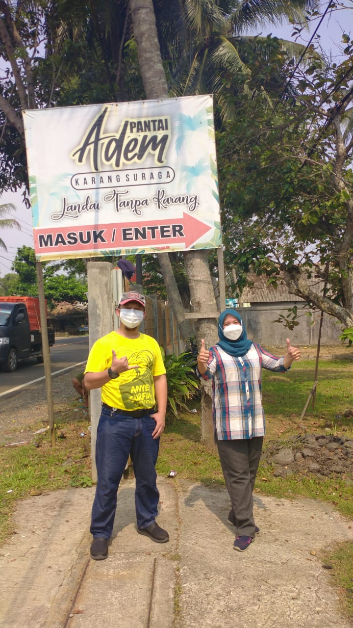 Pengunjung berfoto di depan pintu masuk Pantai Adem.
