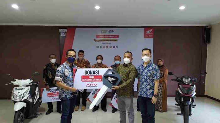 General Manager Corporate Communication AHM - Ahmad Muhibbuddin (kiri) didampingi Manager Satu Hati Education Program PT Capella Dinamik Nusantara - Aceh Budi Lie (kanan) secara simbolis menyerahkan donasi unit sepeda motor Honda kepada Kepala SMKN 1 Teunom, Bpk. Syaribuddin, MPd (tengah).