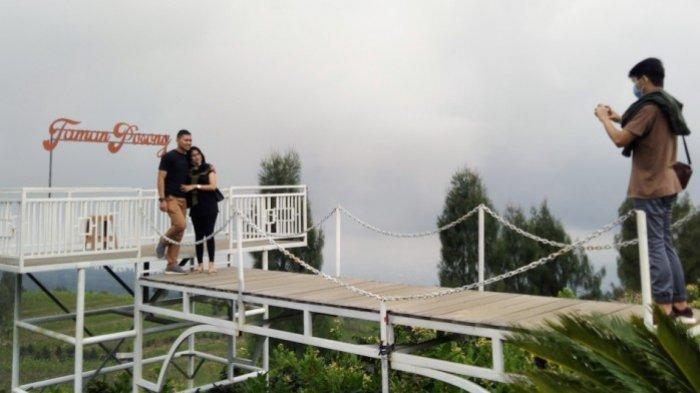Pengunjung foto di spot foto yang disediakan pengelola tempat wisata Posong di lembah Gunung Sindoro, Kabupaten Temanggung, Minggu (11/10/2020).